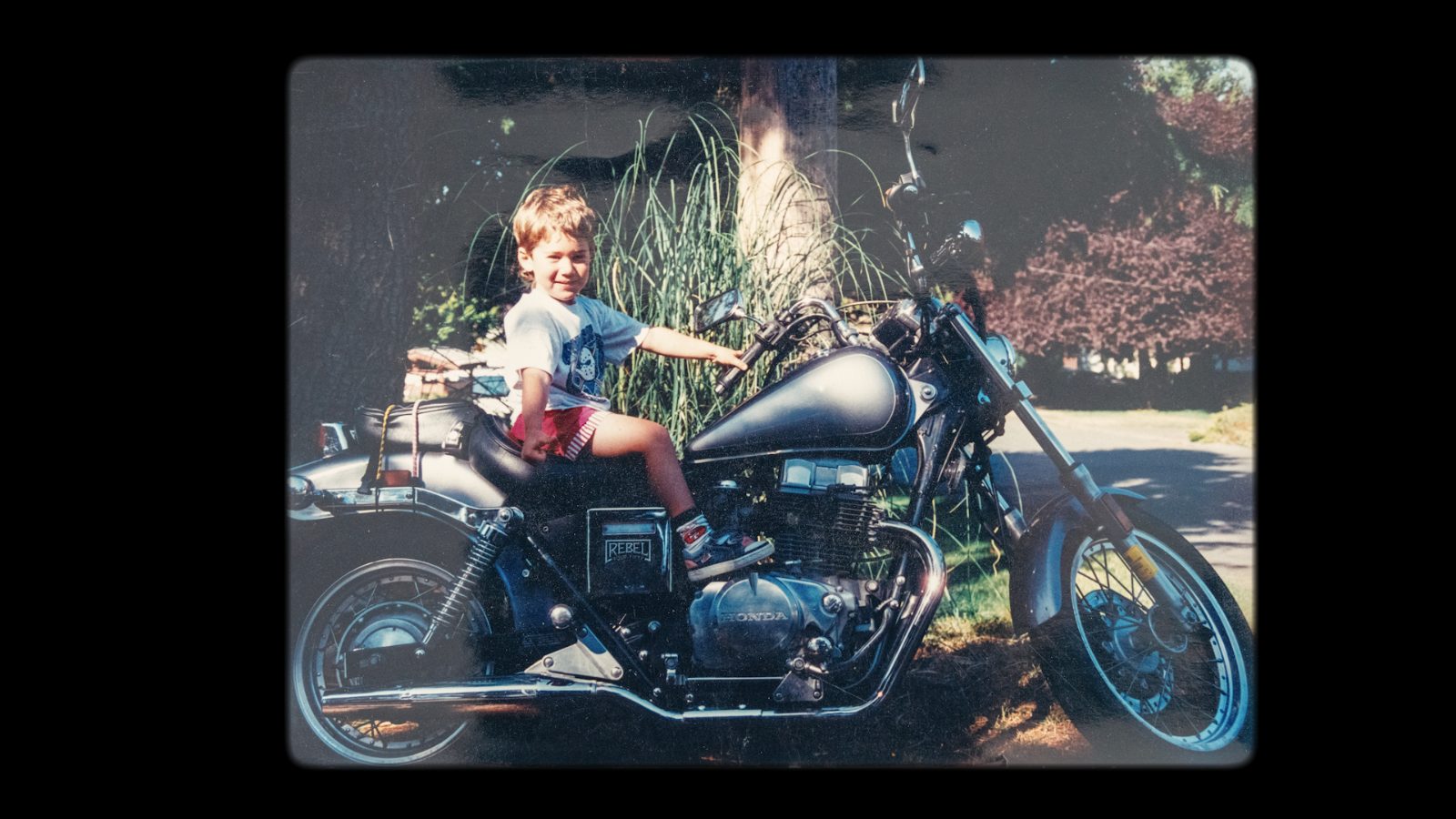 Vintage photo of a small boy on a Honda Rebel motorcycle